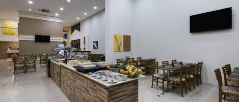 A buffet area with a variety of food items and a seating area with chairs and tables.