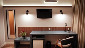 Una habitación moderna con escritorio, silla y televisor de pantalla plana en la pared.