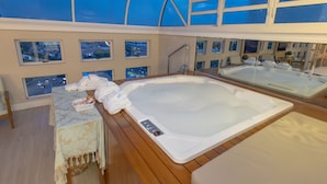 A spa area with a hot tub, wooden flooring, and multiple windows offering city views. - Lizon Curitiba Hotel (Curitiba)