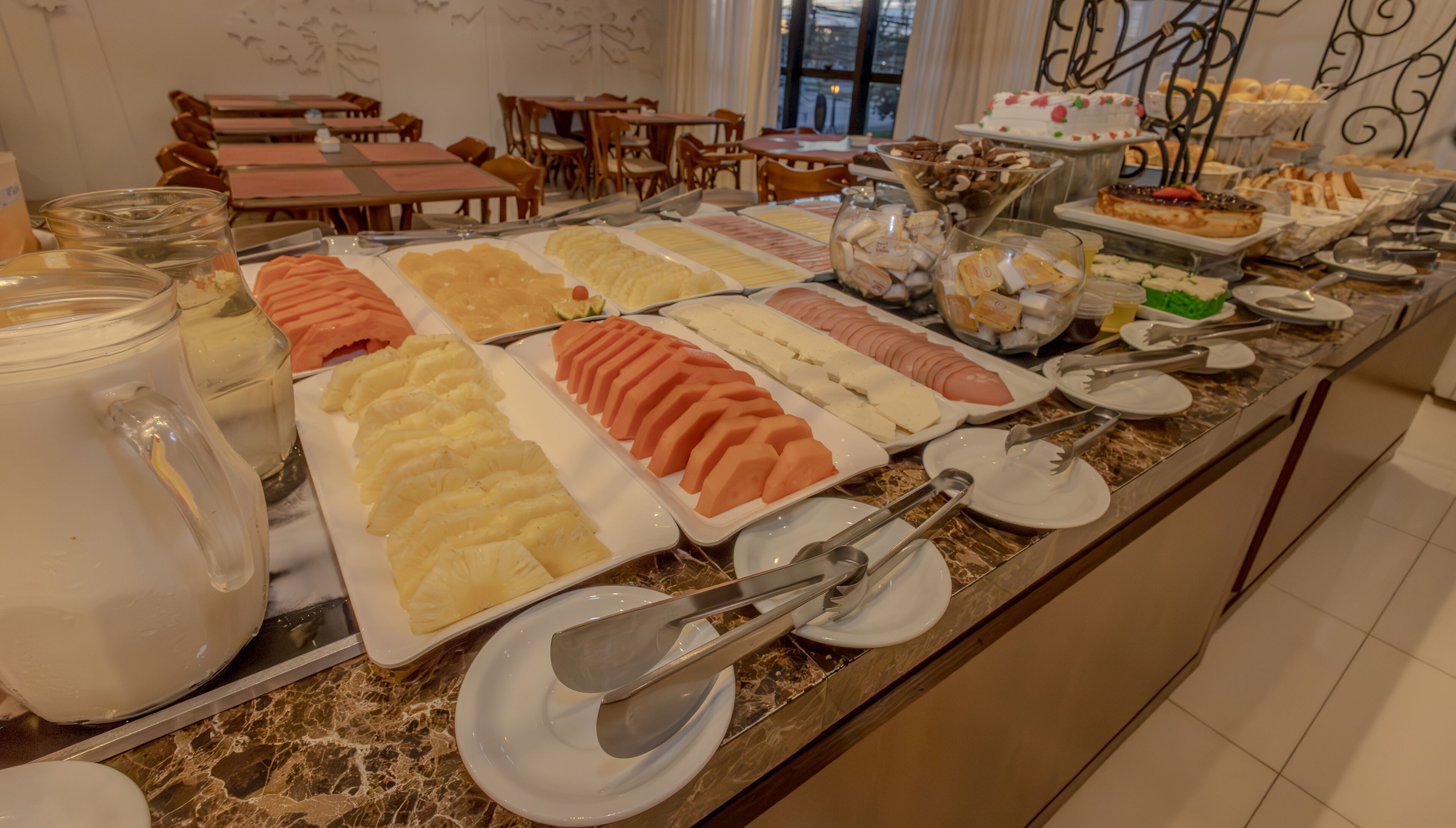 A buffet with various food items and utensils.