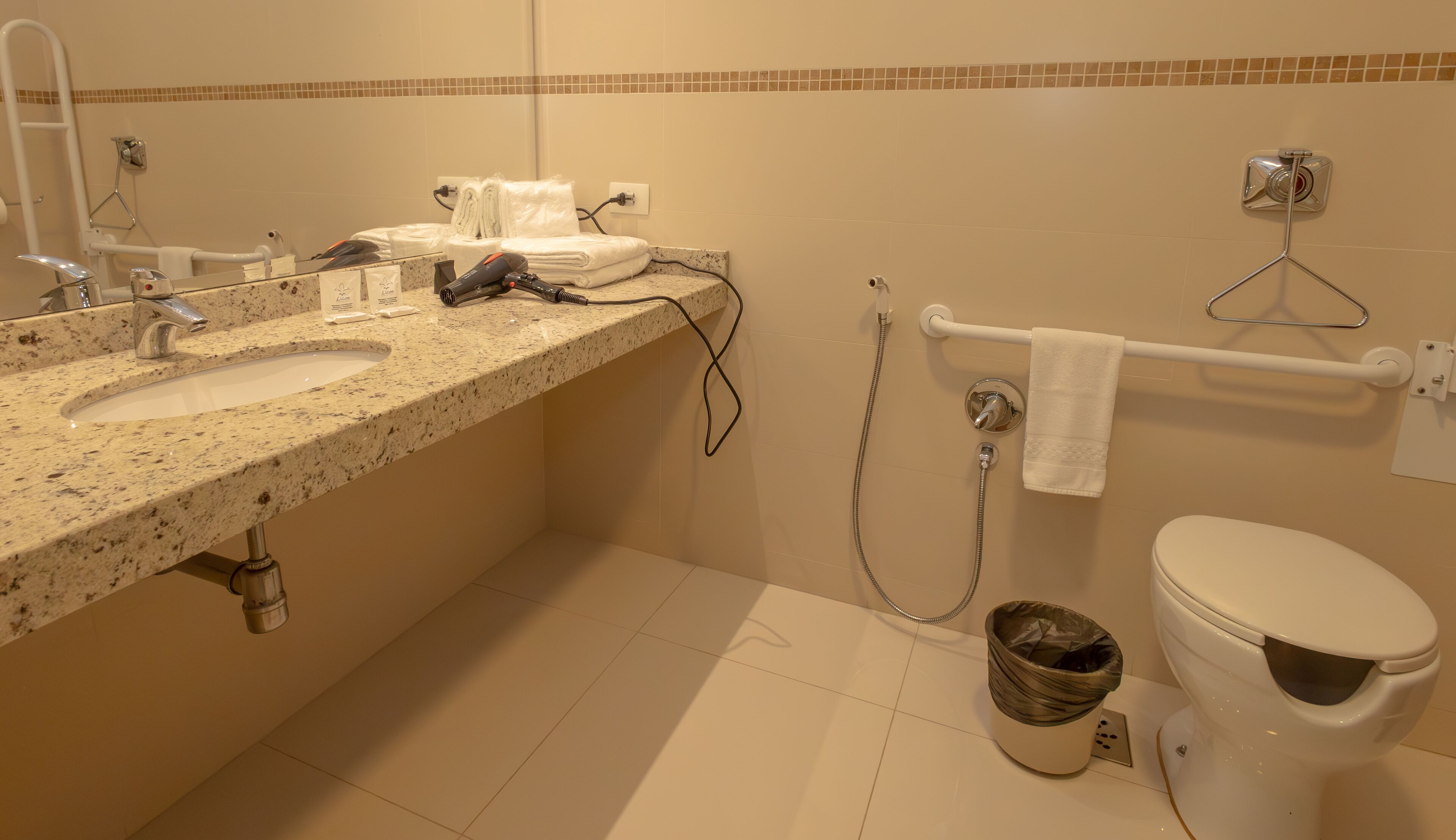 A bathroom with two sinks, a toilet, a shower, and a towel rack.