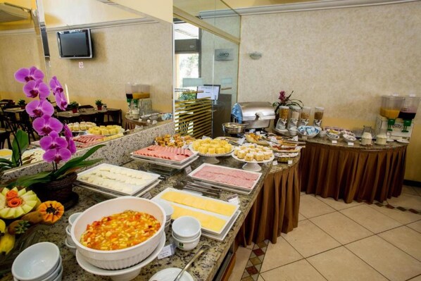 A buffet with various food items, a television, and a coffee station.