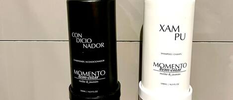 Two bottles of shampoo on a reflective surface.