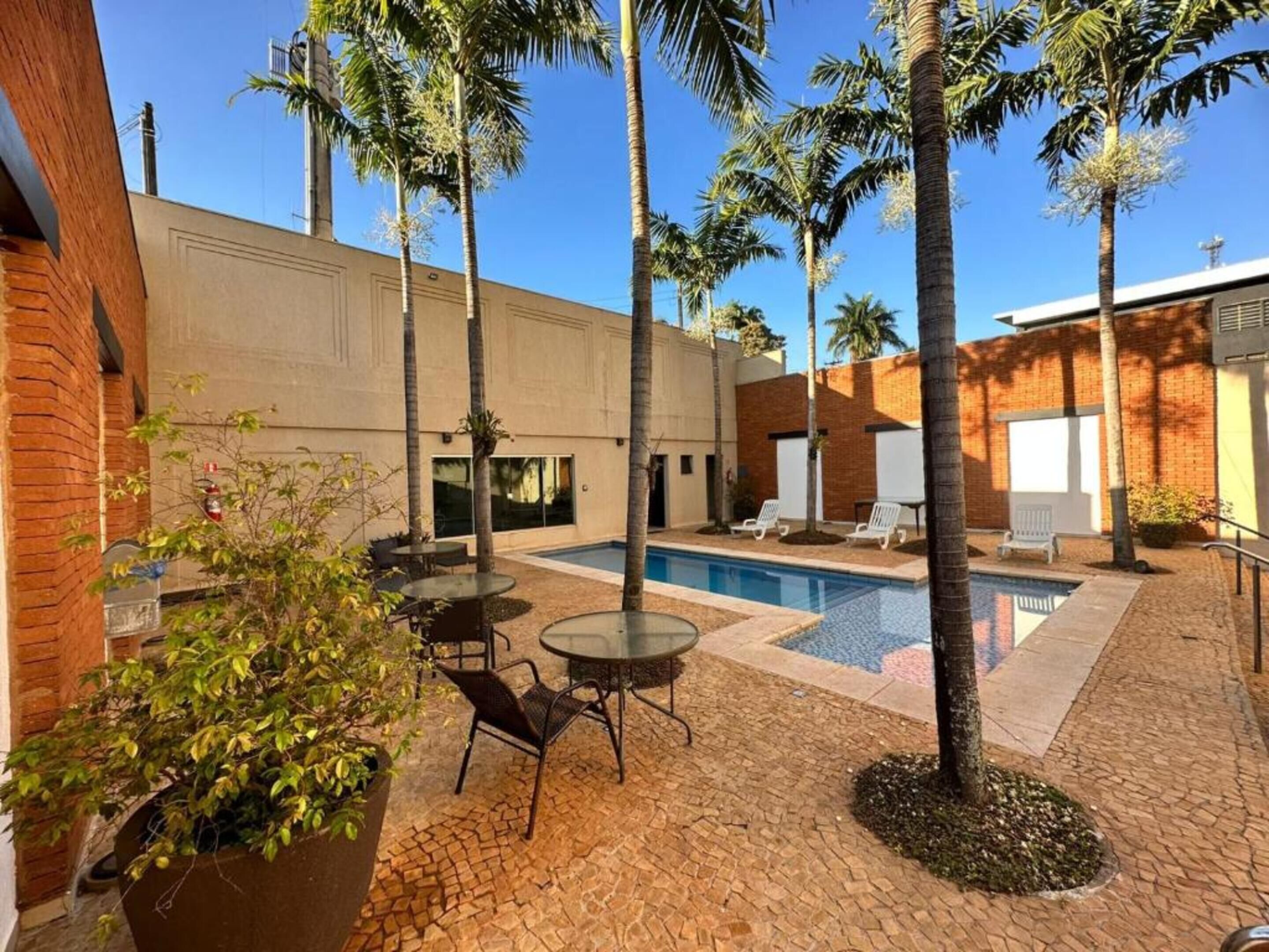 Una piscina al aire libre, sillones reclinables de piscina