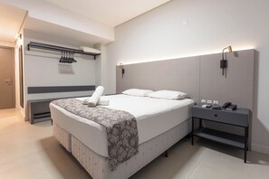 Relax in comfort with a large bed, bench, and convenient bedside table.