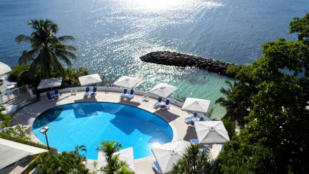 Una piscina al aire libre, sillones reclinables de piscina