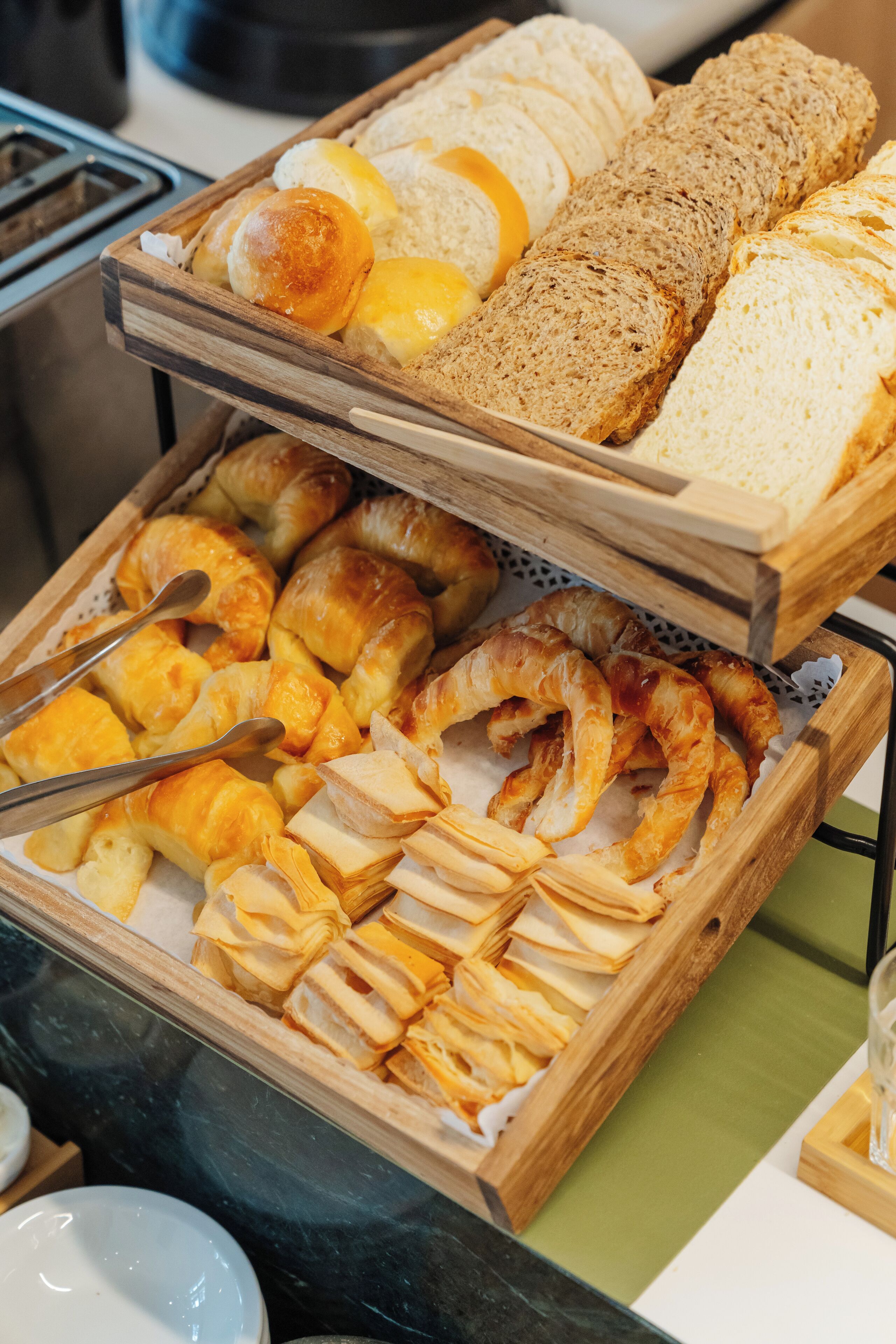 Un bufé con pan, croissants y bollería.