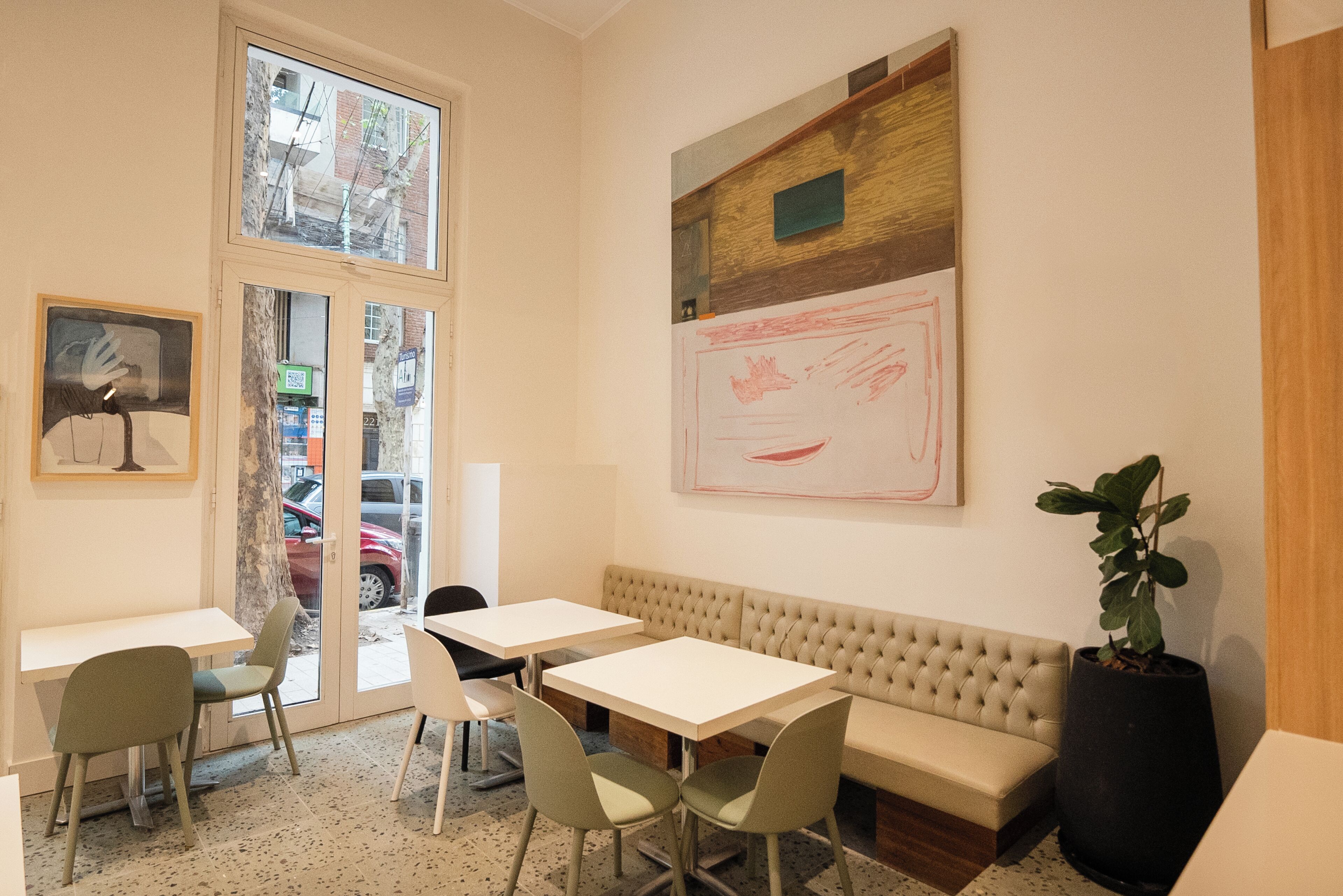 A modern interior with a seating area, tables, and artwork on the walls.