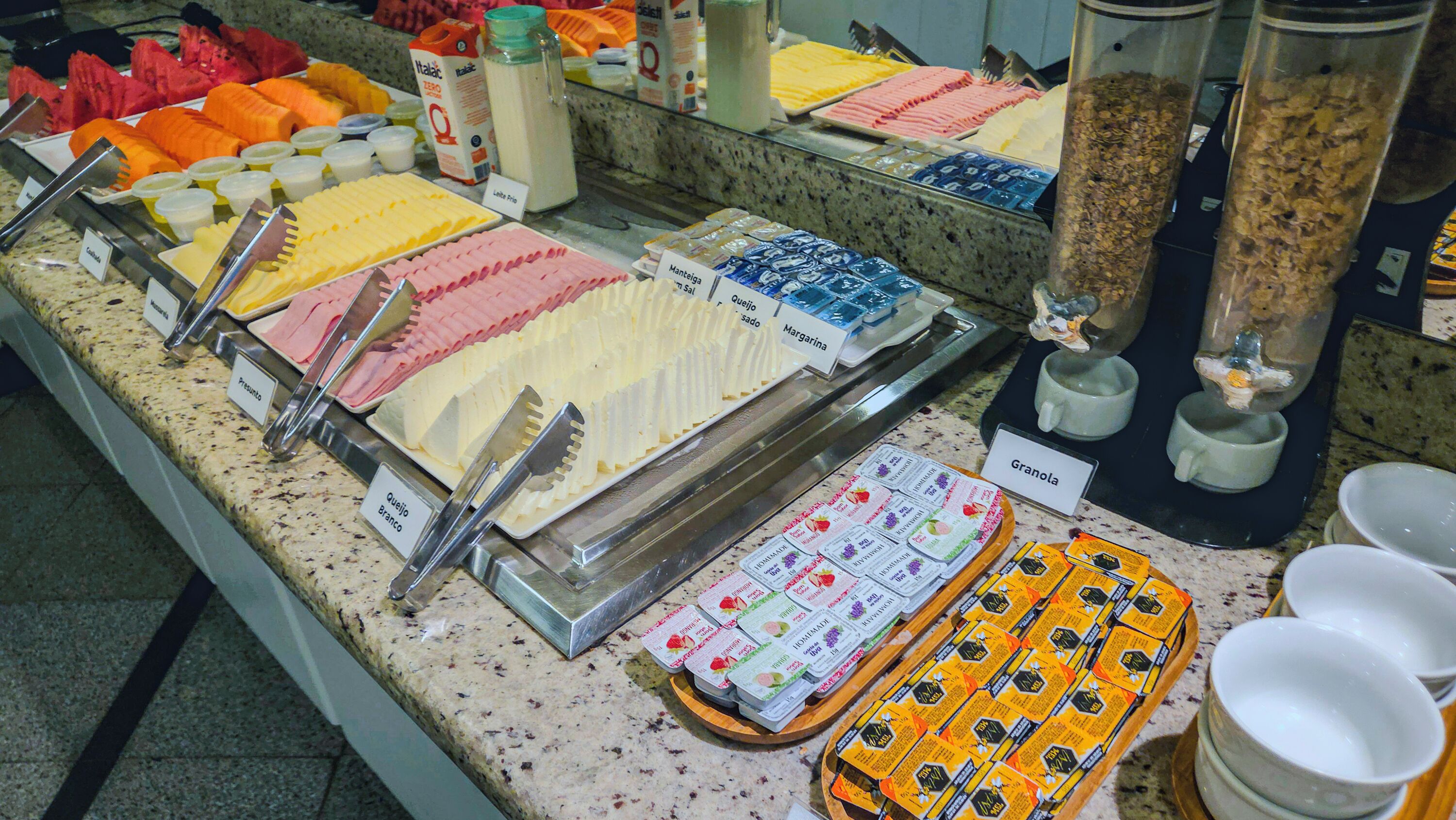 A buffet with various food items and utensils.