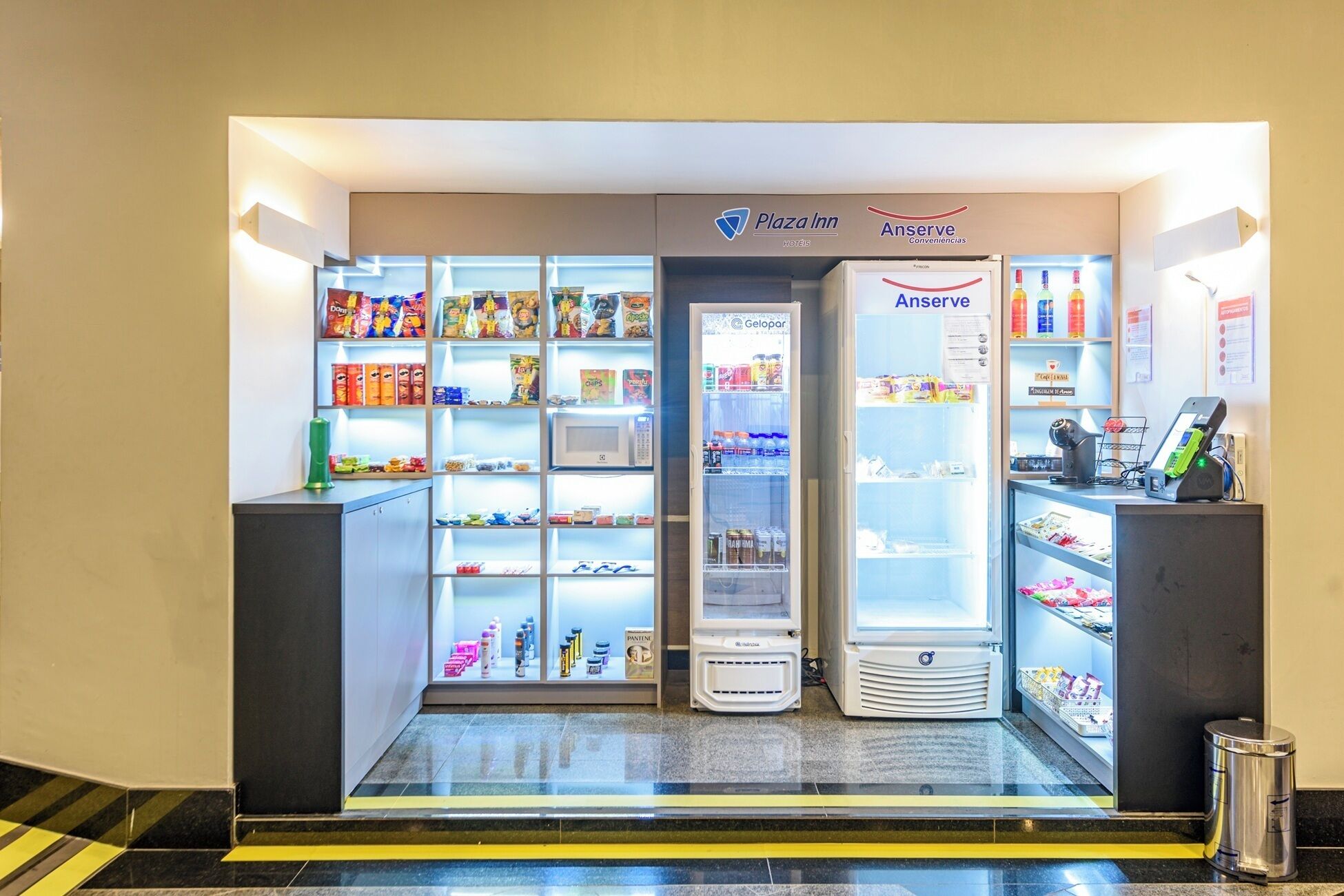 A self-service kiosk area with a microwave, beverage dispensers, and a cash register.