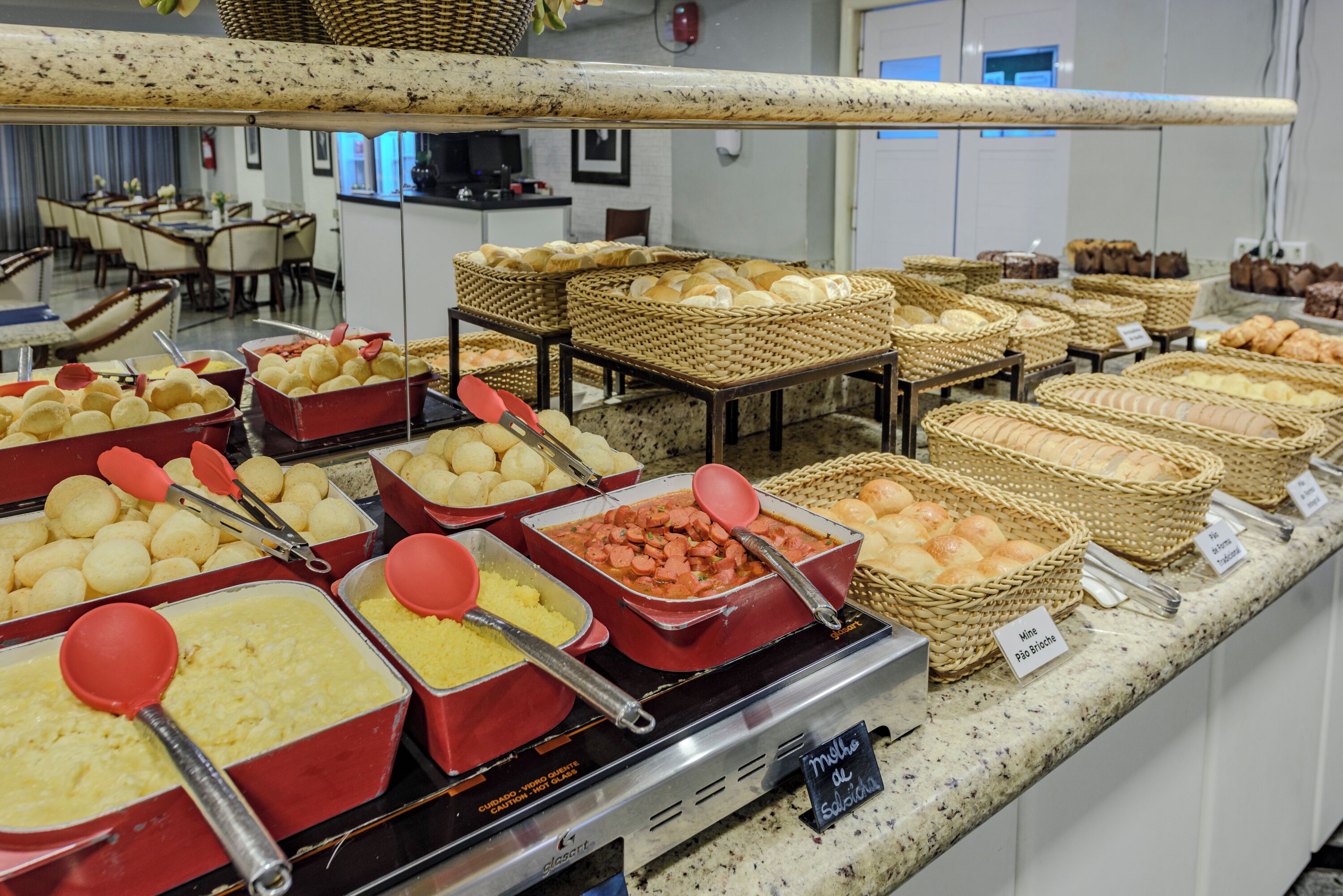 A buffet with various food items and baskets.