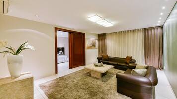 A modern living room with a sofa, coffee table, and a large vase of flowers.