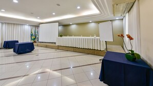 A conference room with a whiteboard, tables, and a projector screen. - Plaza Inn Augustus - Downtown (Goiania)