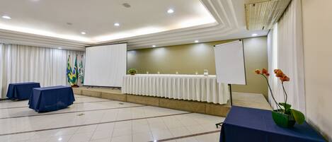 Una sala conferenze con lavagna, tavoli e schermo per proiettore.