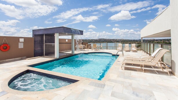 A rooftop pool with a hot tub, lounge chairs, and a view of the city. - Transamerica Lagoa Santa (Lagoa Santa)
