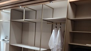A modern closet with multiple shelves and hanging space, featuring a minimalist design and a wooden floor. - Transamerica Lagoa Santa (Lagoa Santa)