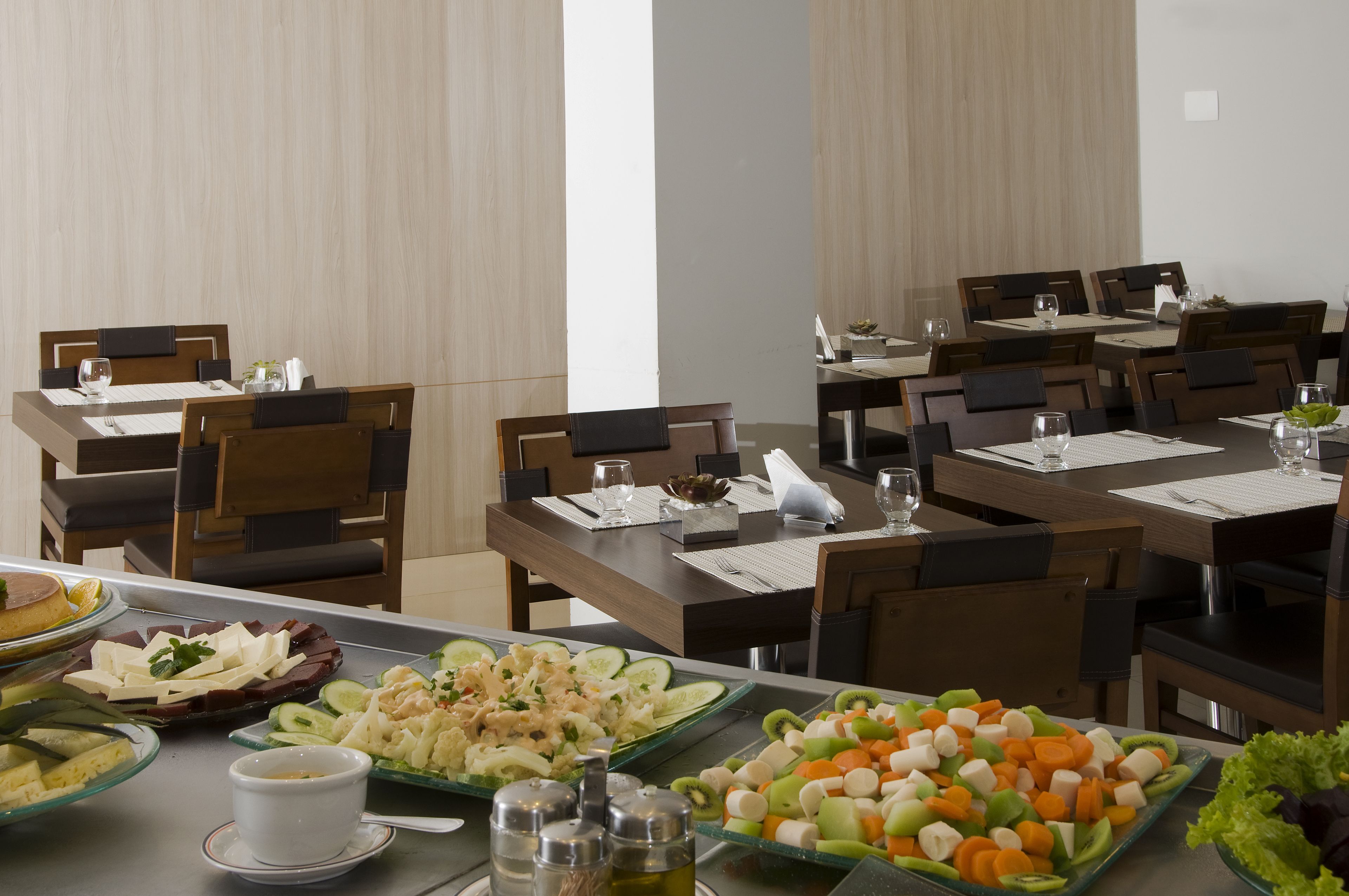 A dining area with multiple tables set for meals, each with plates of food, glasses, and cutlery.