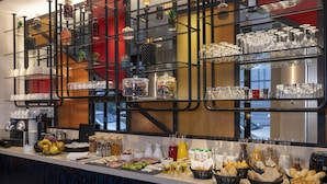 A buffet setup with various food items, glassware, and decorative plants. - Le 12 Hotel (Paris)