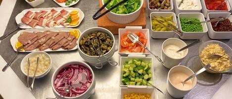 Una mesa de buffet con diversos alimentos y salsas.