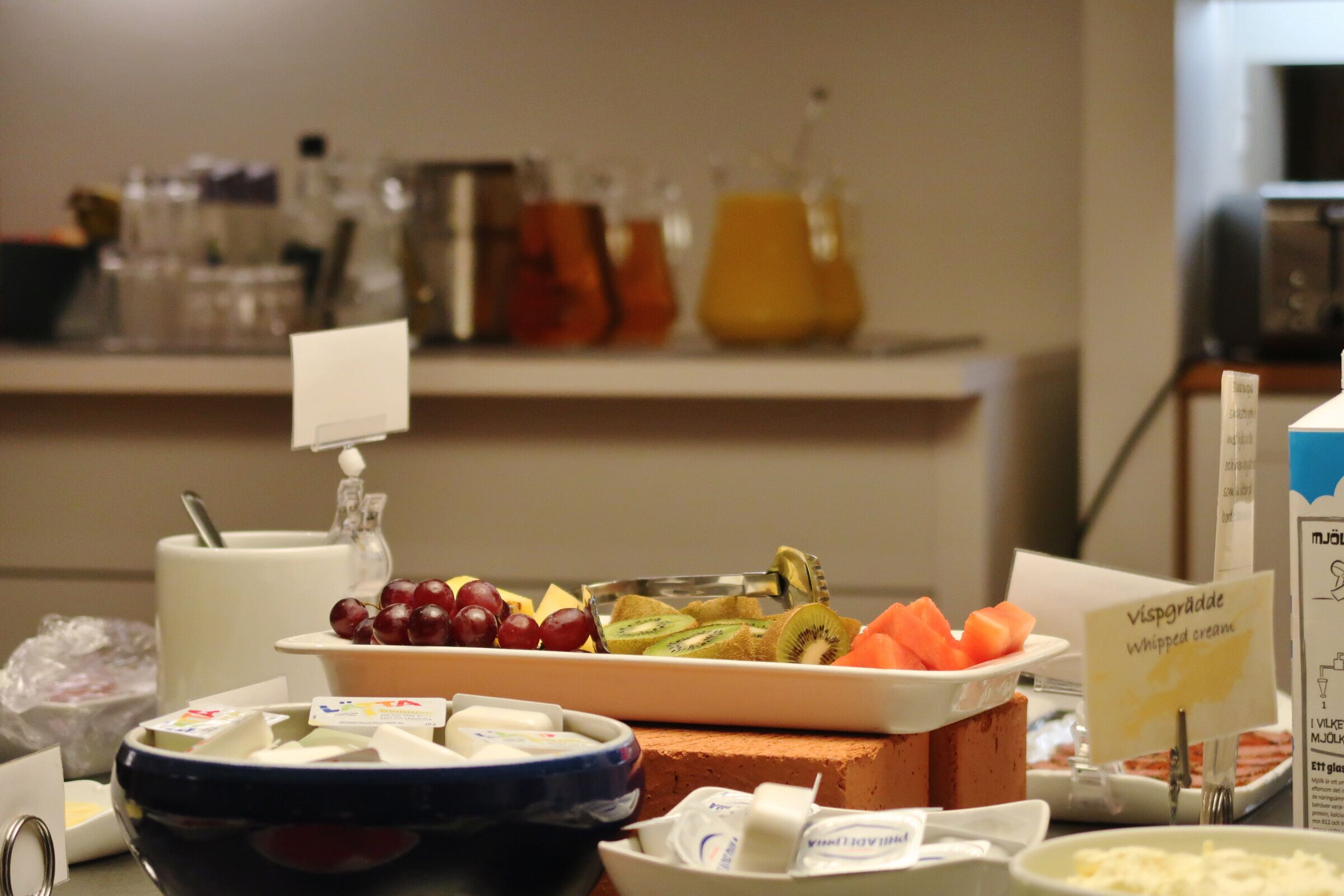 Ein Buffet mit verschiedenen Speisen, darunter Obst, Käse und Sahne.