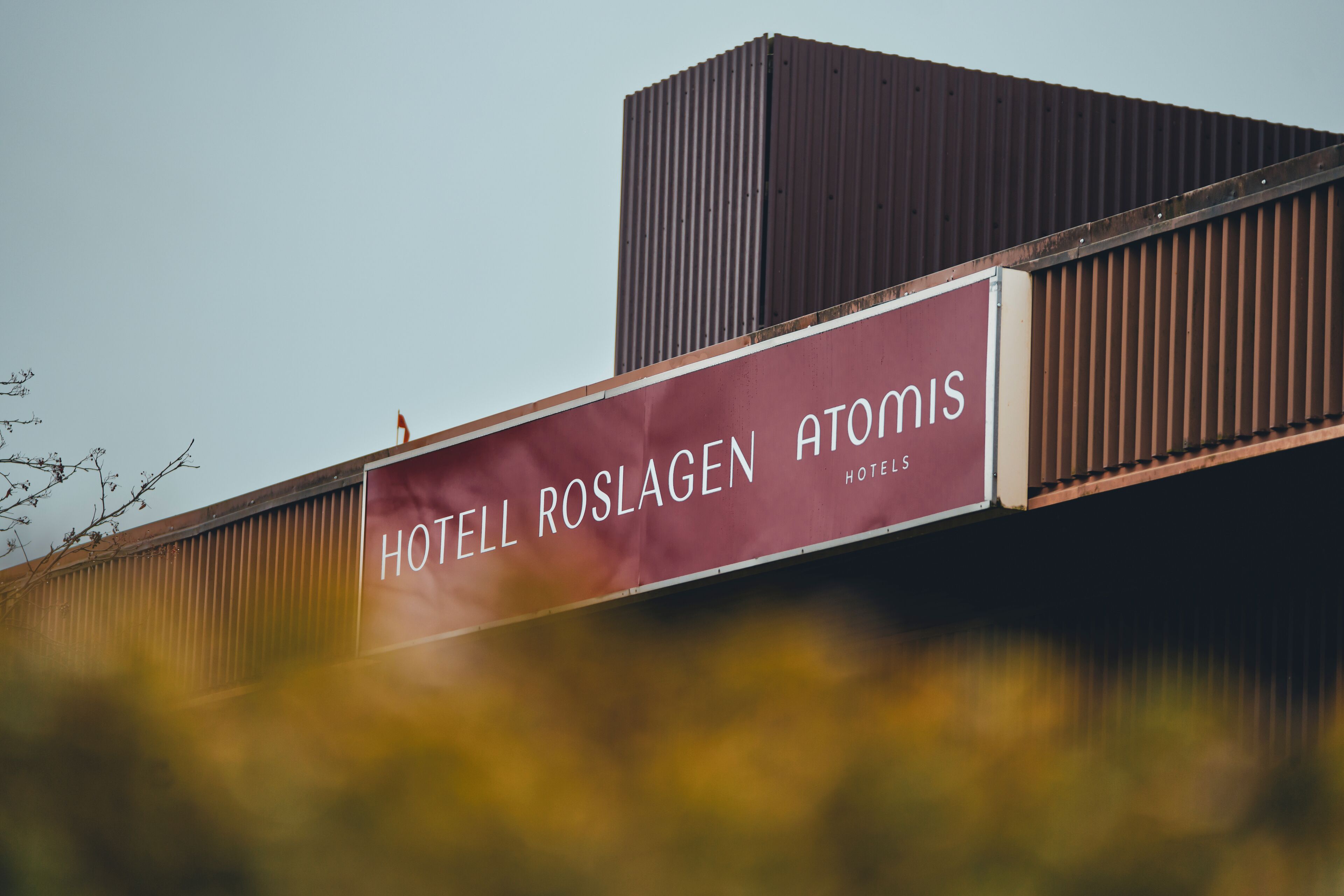 Een hotelsbord met de naam 'HOTELL ROSLAGEN ATOMIS'.