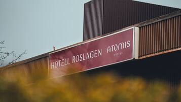 Een hotelsbord met de naam 'HOTELL ROSLAGEN ATOMIS'.