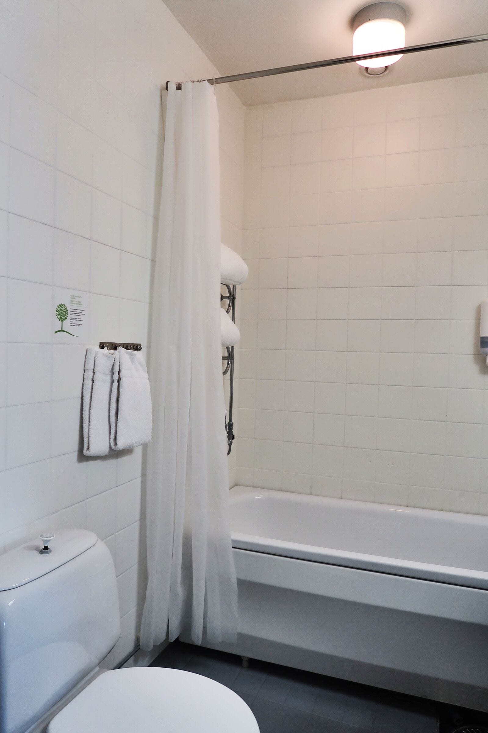 Un baño con inodoro, bañera y cortina de ducha.