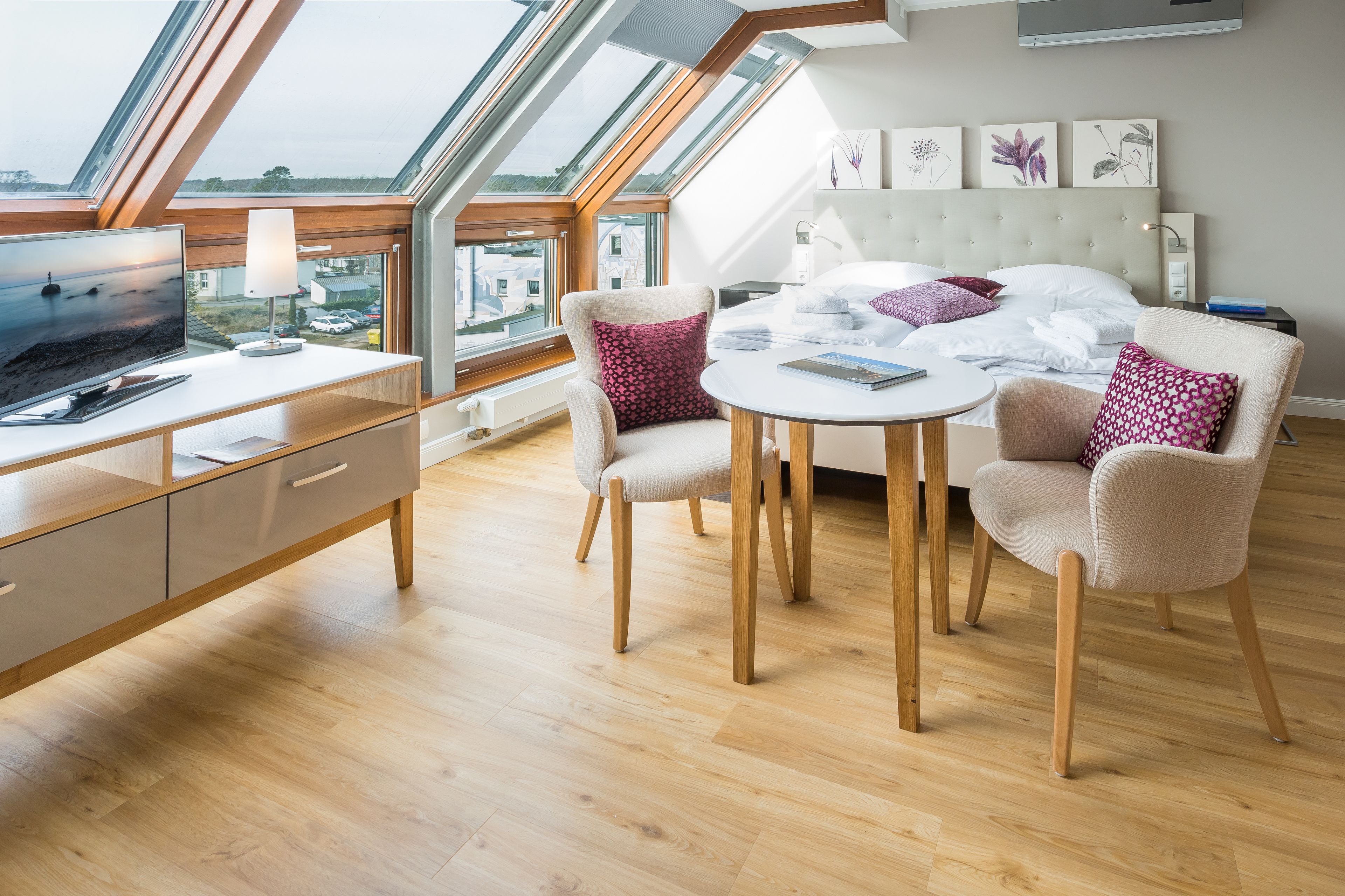 Un dormitorio moderno con tragaluces, una cama, un escritorio y una silla.