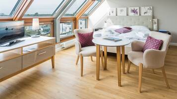 Un dormitorio moderno con tragaluces, una cama, un escritorio y una silla.