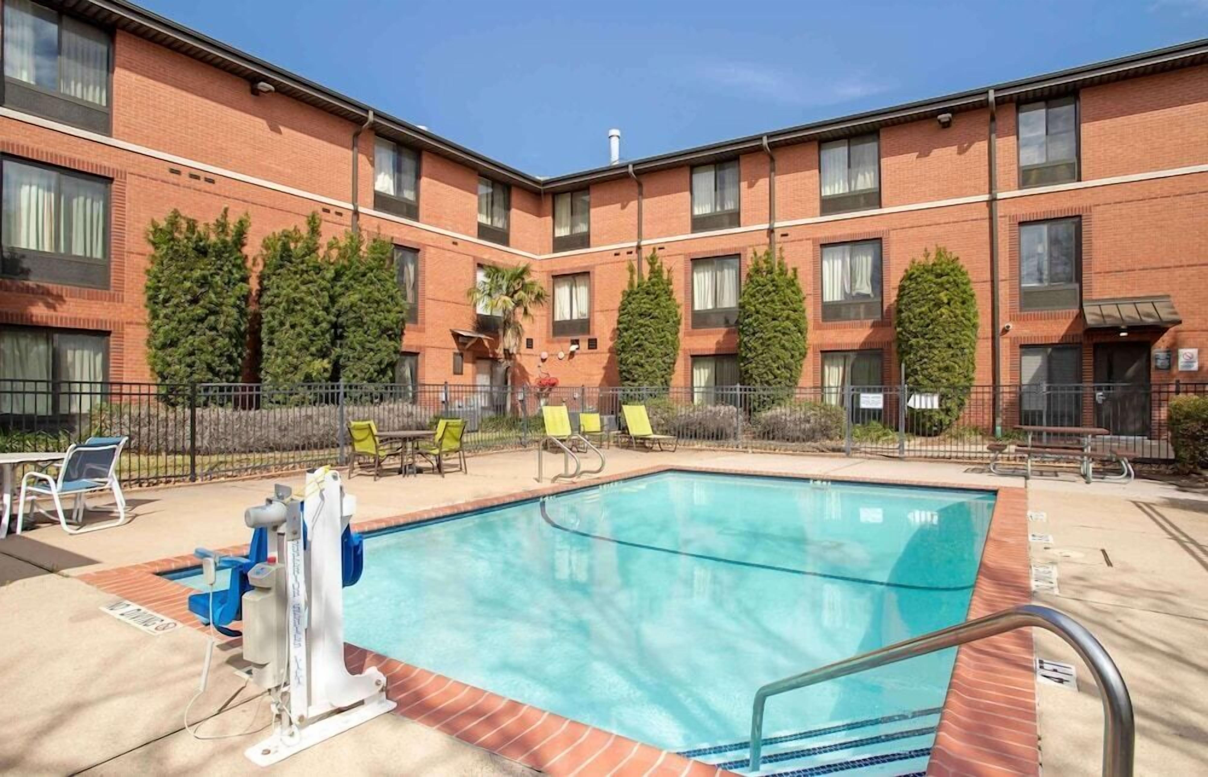 A swimming pool with lounge chairs and a lifeguard stand.