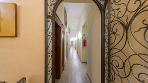 A hallway with a metal archway leading to a room. - Hotel Cosimo De' Medici (Florence)