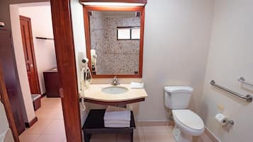 A bathroom with a sink, mirror, toilet, and a towel rack.