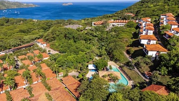 Relax in a serene hillside setting with expansive ocean views and a stunning pool surrounded by lush greenery.