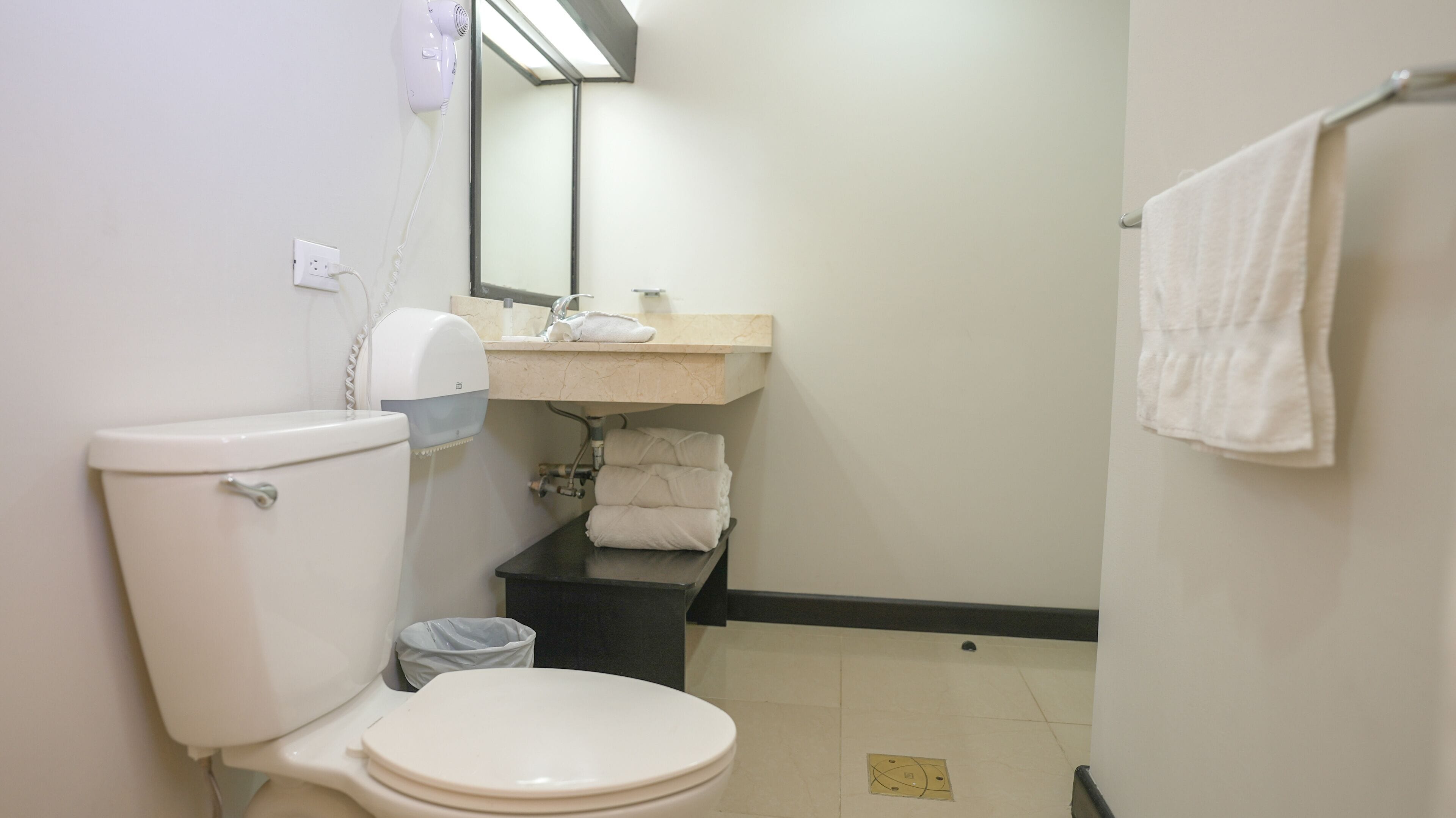 Ein kleines Badezimmer mit Toilette, Waschbecken und Handtuchhalter.