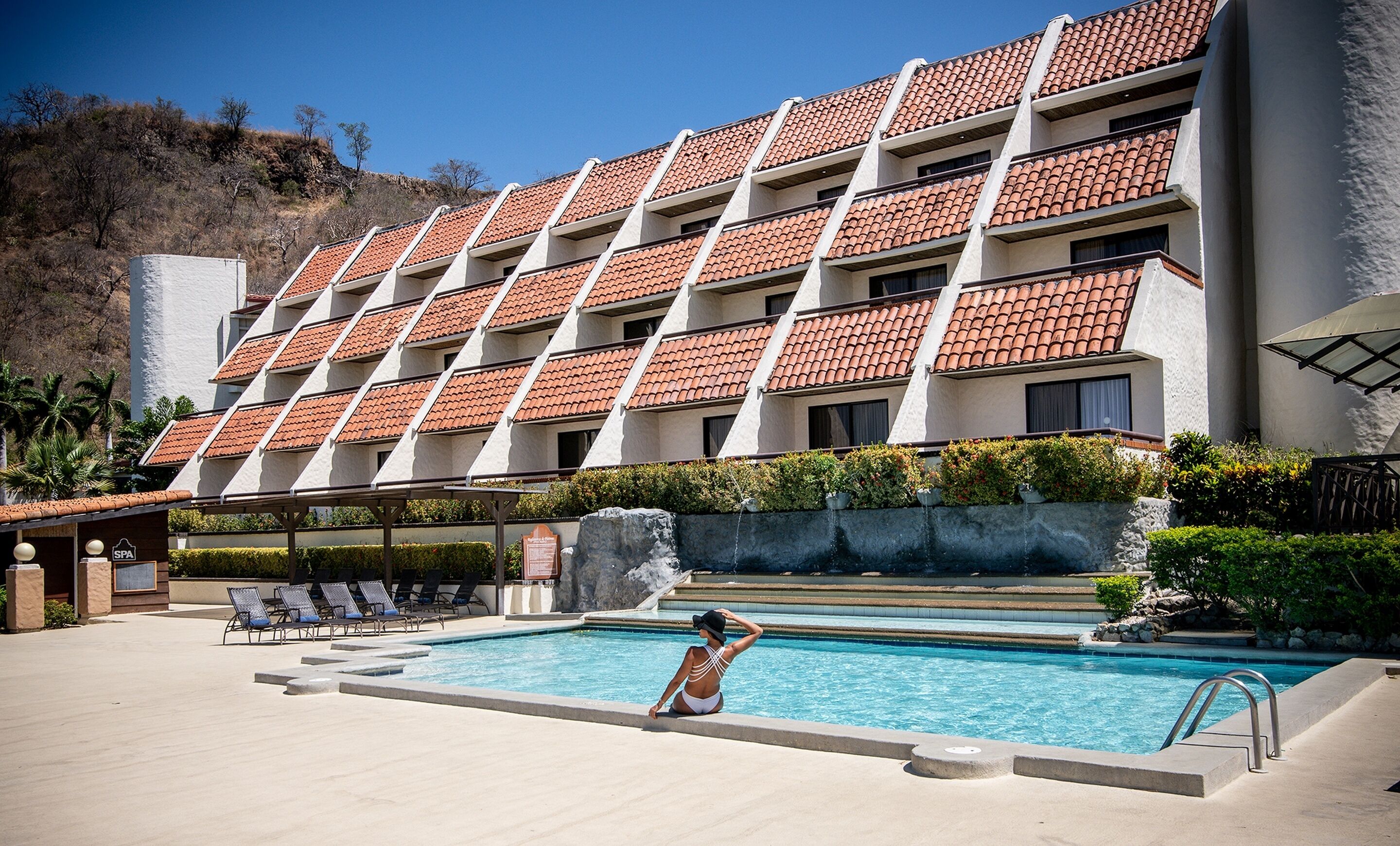 Un hotel con zona de piscina, varios balcones y un spa.