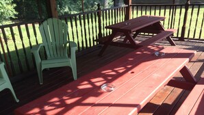 Una terraza de madera con mesas y sillas de picnic.