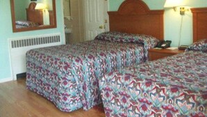Una habitación con dos camas, cabecero de madera, espejo, un cuadro enmarcado y una lámpara de noche.