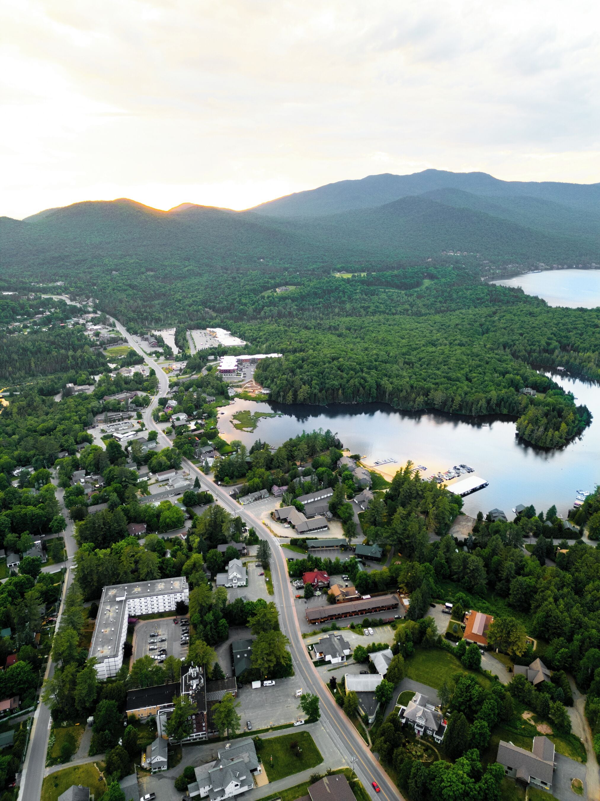 An aerial view of a lakeside community with residential buildings, roads, and a marina.