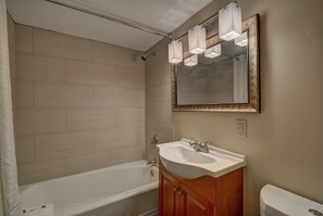 A bathroom with a bathtub, a sink, and a toilet.