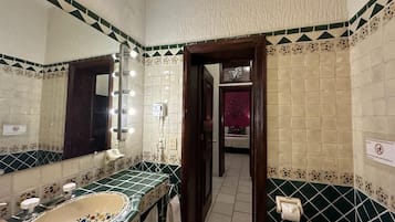 Ein Badezimmer mit großem Spiegel, Waschbecken und Toilette.