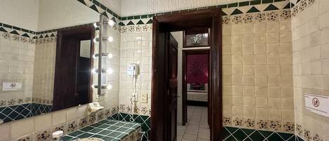 A bathroom with a large mirror, a sink, and a toilet.