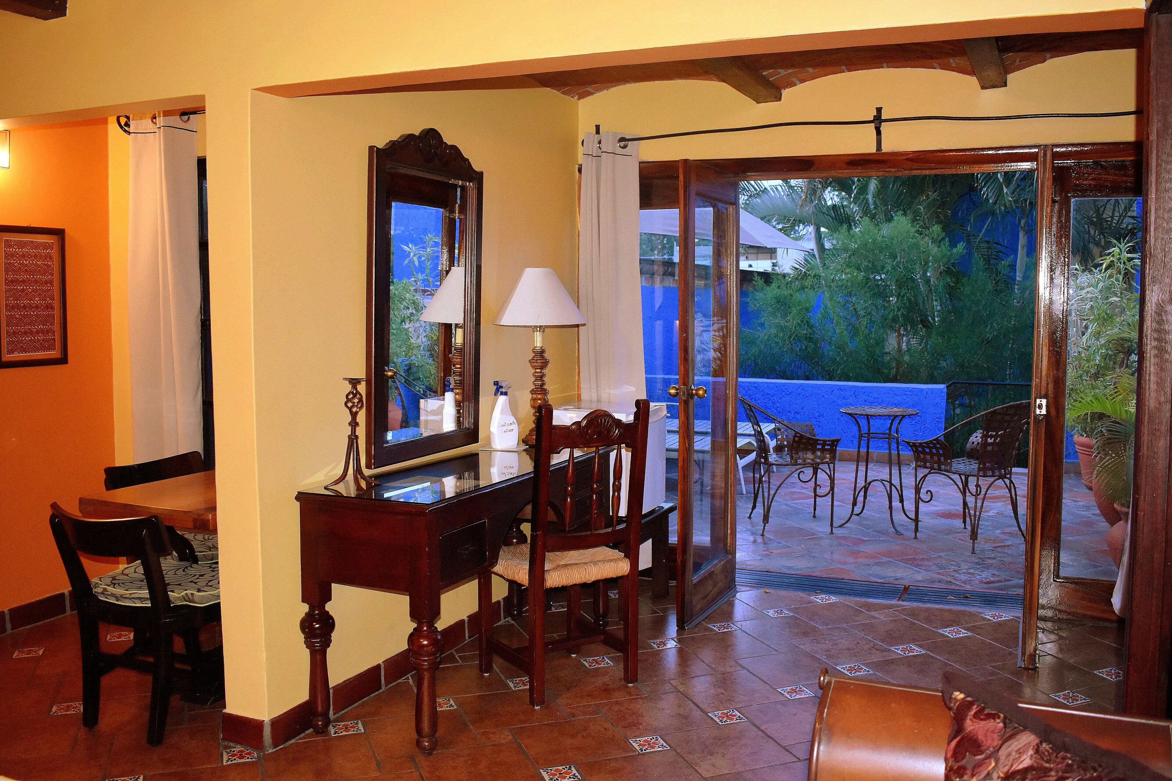 Comedor con mesa, sillas, espejo y lámpara. Balcón exterior con sillas y mesa.