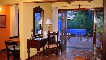 Comedor con mesa, sillas, espejo y lámpara. Balcón exterior con sillas y mesa.