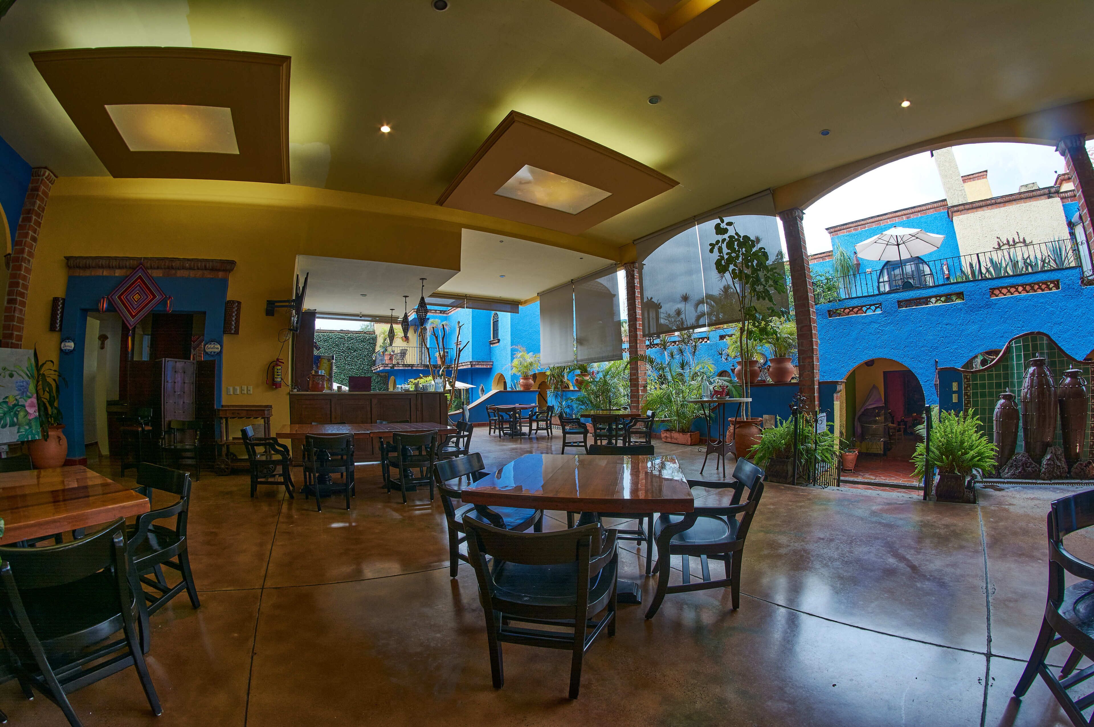 A spacious indoor area with high ceilings, large windows, and multiple seating arrangements.