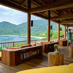 Relax on the deck with seating and take in the breathtaking views of the tropical beach and lush mountains.