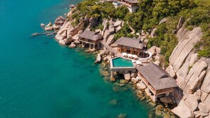A resort with overwater bungalows connected by a bridge, a swimming pool, and a beach. - Six Senses Ninh Van Bay (Dong Ninh Hoa)