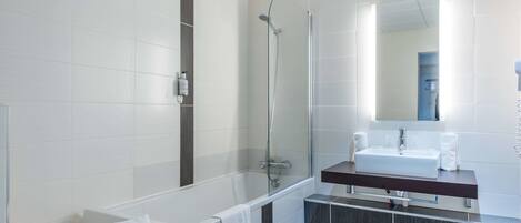 A modern bathroom with a glass-enclosed shower, a white sink, and a dark-toned vanity.
