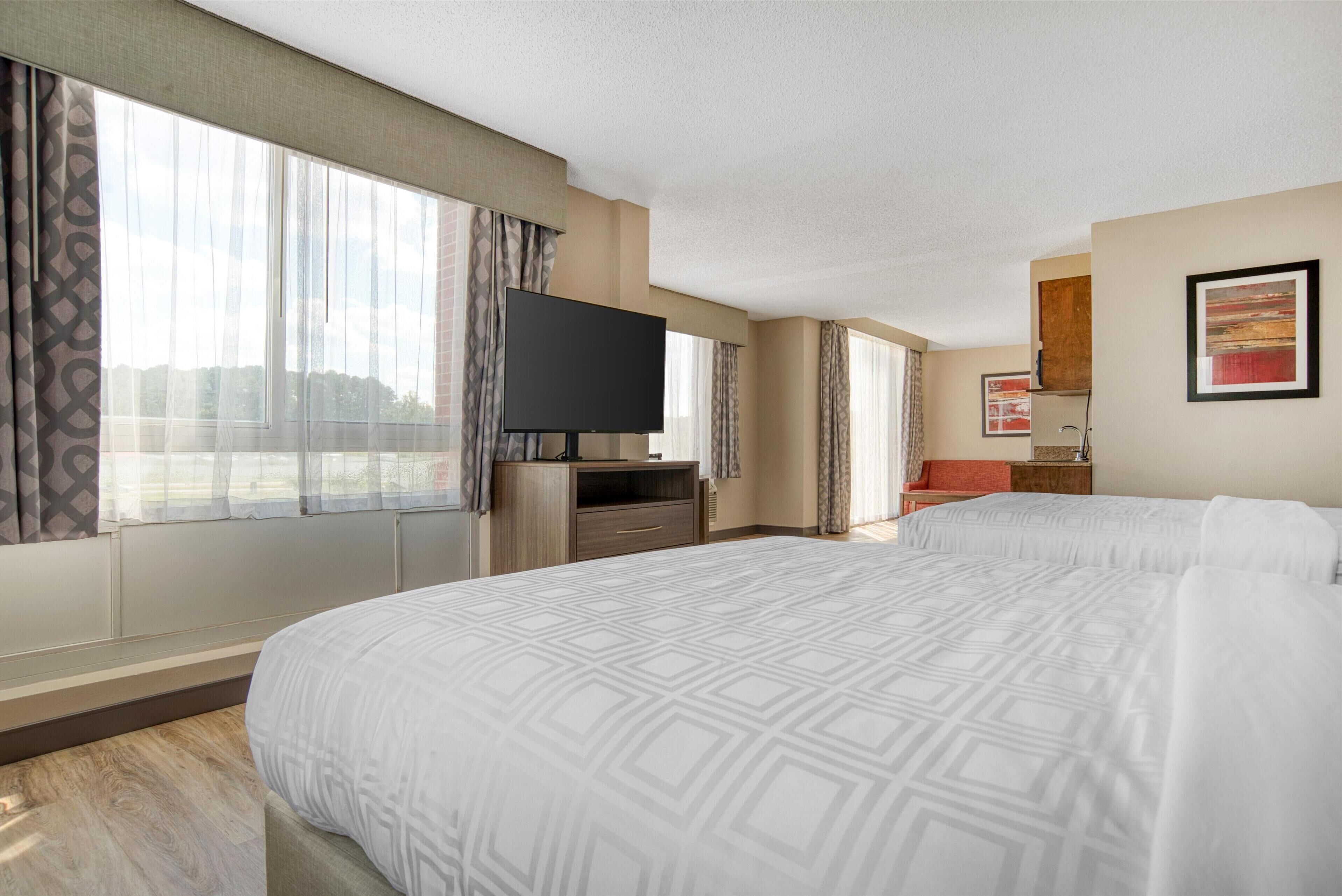 suite, 2 queen beds, non smoking, microwave | in-room safe, desk, iron/ironing board, free cots/infant beds