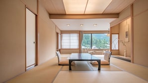 Una habitación japonesa tradicional con suelo de tatami, una mesa baja y puertas correderas.