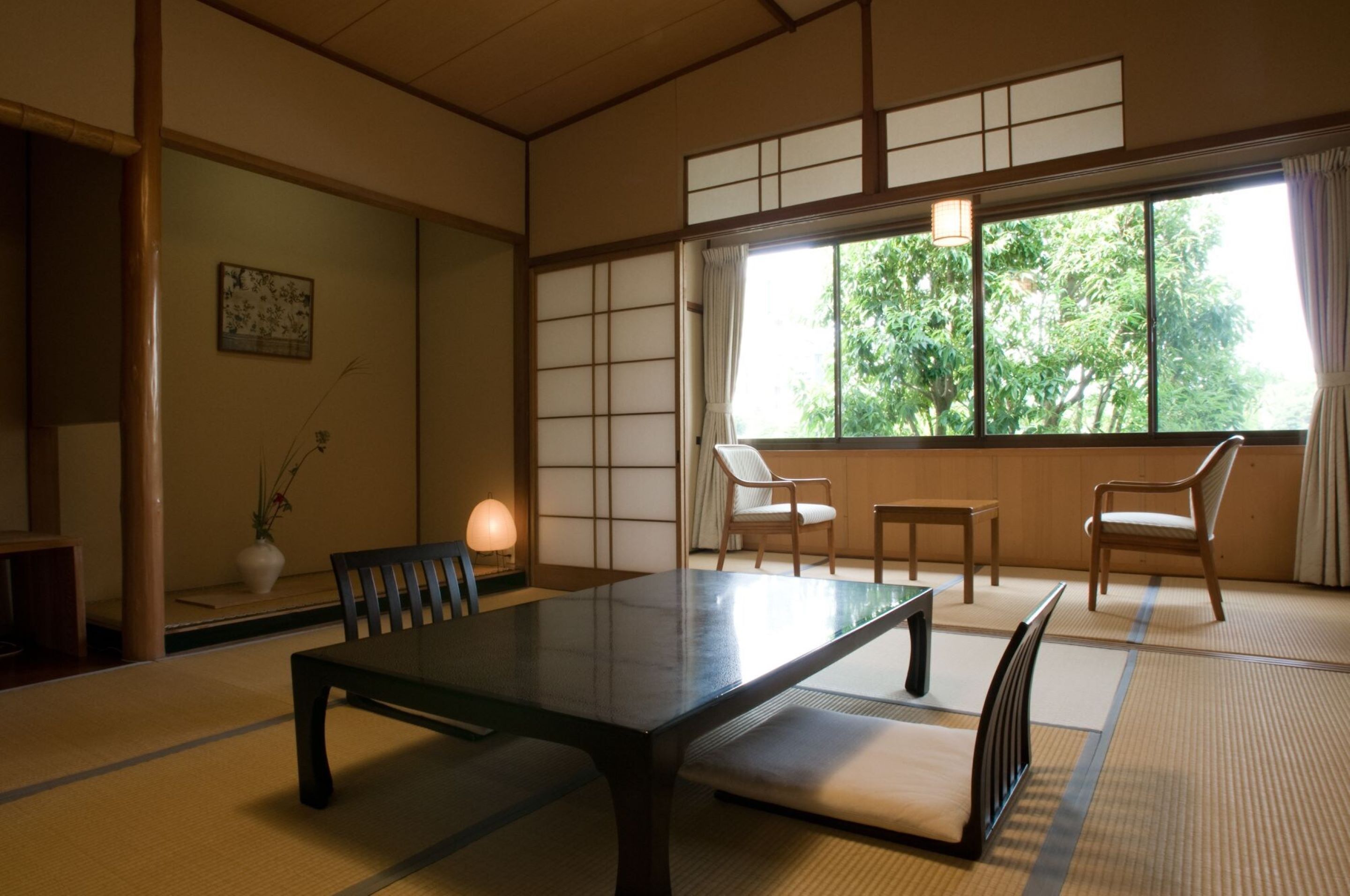 A traditional Japanese-style room with tatami flooring, a low table, and sliding doors.